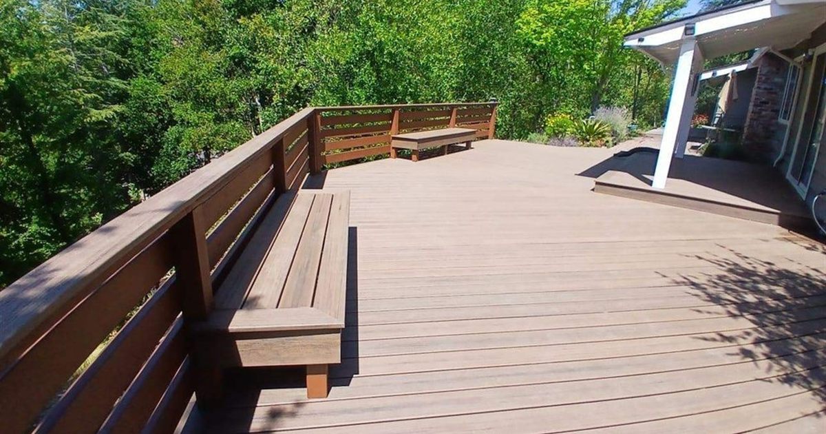 Brown composite decking with built-in bench on a Seattle deck, weighing composite decking pros and cons in person